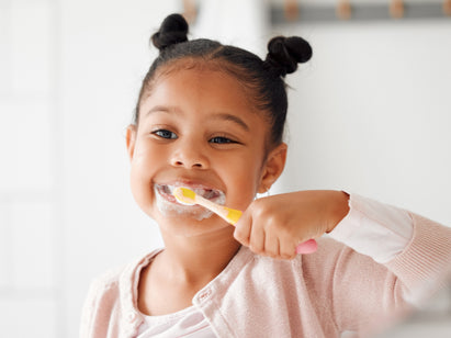 child brushing her teeth